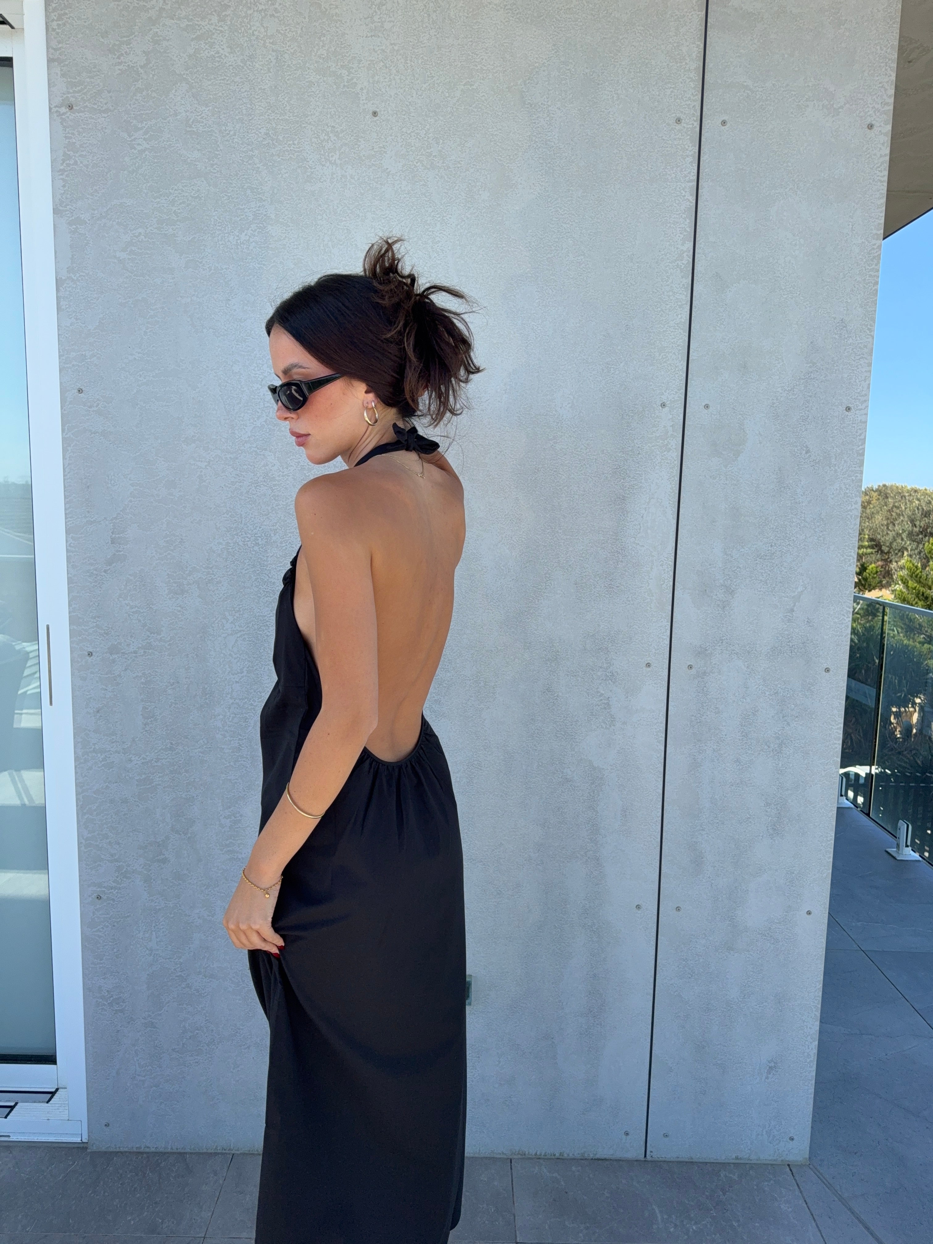Back view of black halter dress with open neckline
