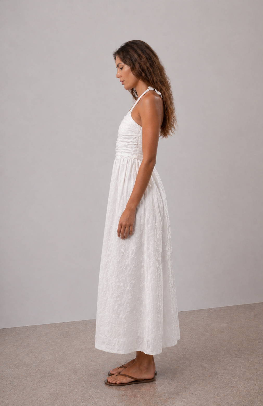 Side view of white halter dress with soft flowing silhouette