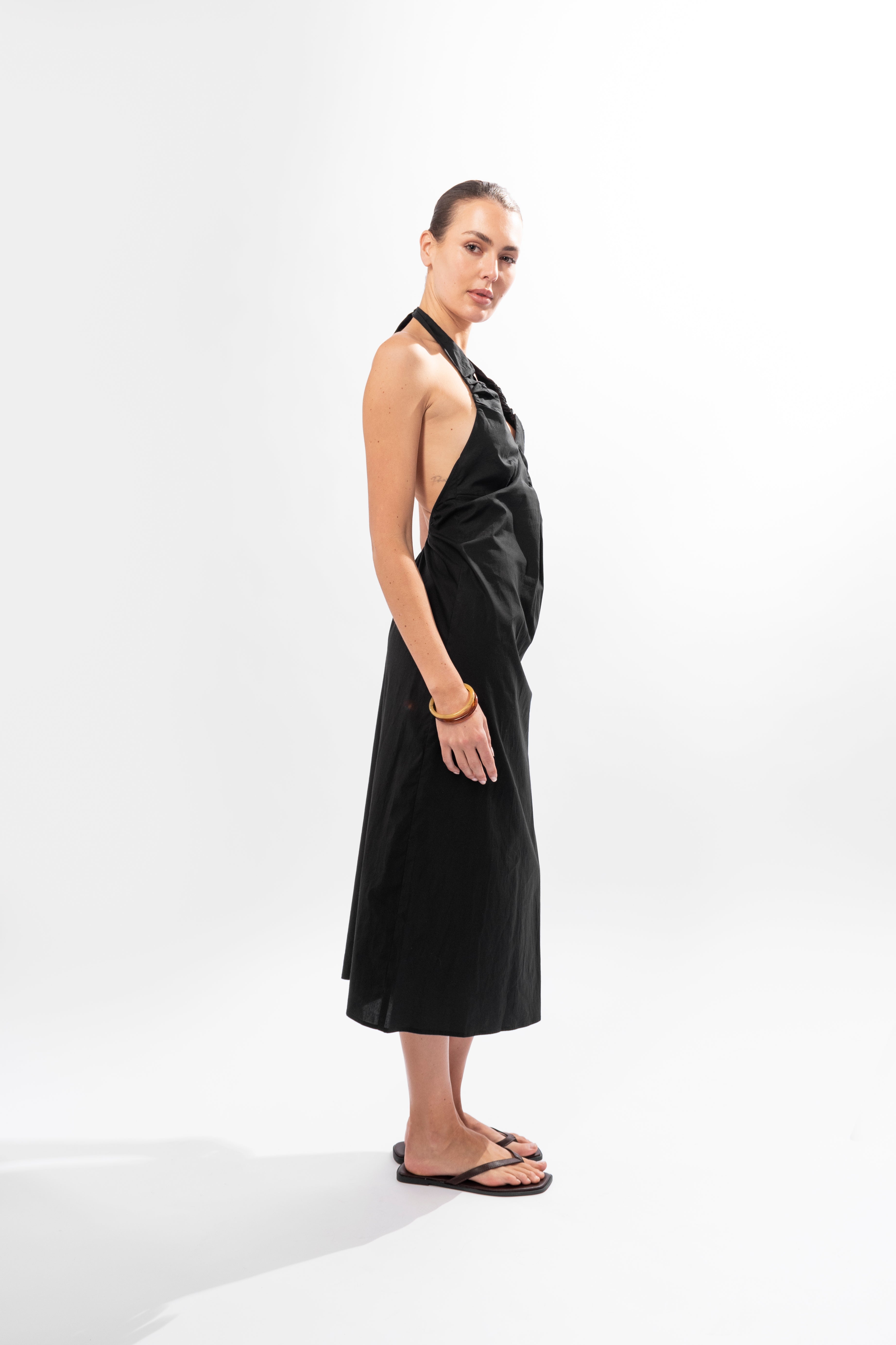 Model wearing black halter dress styled for evening outfit